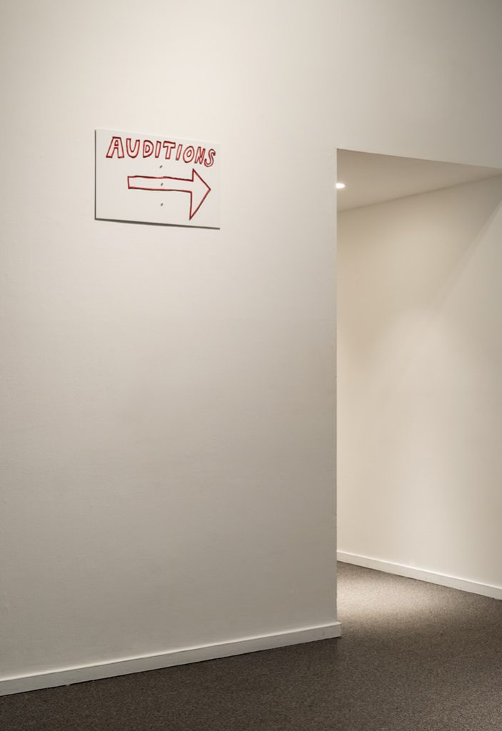 Installation view, My House: Mike Kelley & Ryan Trecartin, Presentation House Gallery, December 19, 2015 – March 6, 2016; Mike Kelley, Street Sign, 2004, two-colour silkscreen on white, baked aluminum panel with three puncture holes. Courtesy Presentation House Gallery and Site Photography.