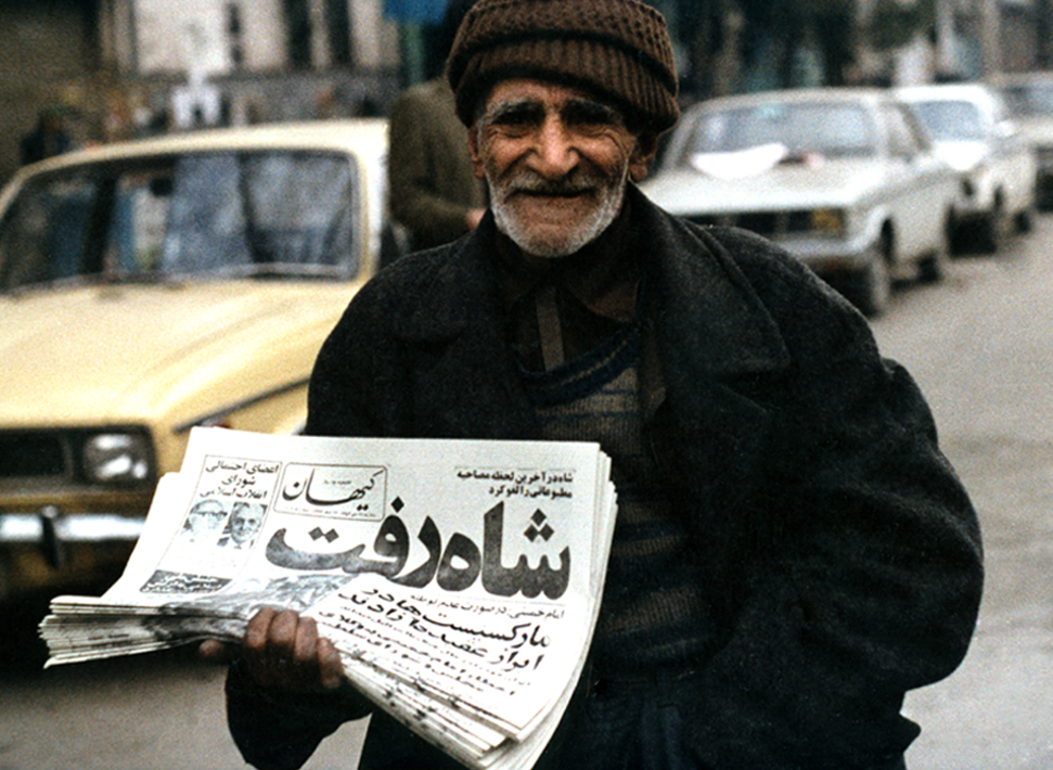 Newspaper Seller Displaying Headline, "Shah Left". January 16, 1979.