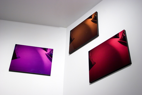 Louise Lawler, installation view Something About Time and Space But I'm Not Sure What It Is, 1998, cibachrome, 24 x 29 1/2" 3 individual works - orange, purple, and red. Courtesy the Artist and Metro Pictures, New York.