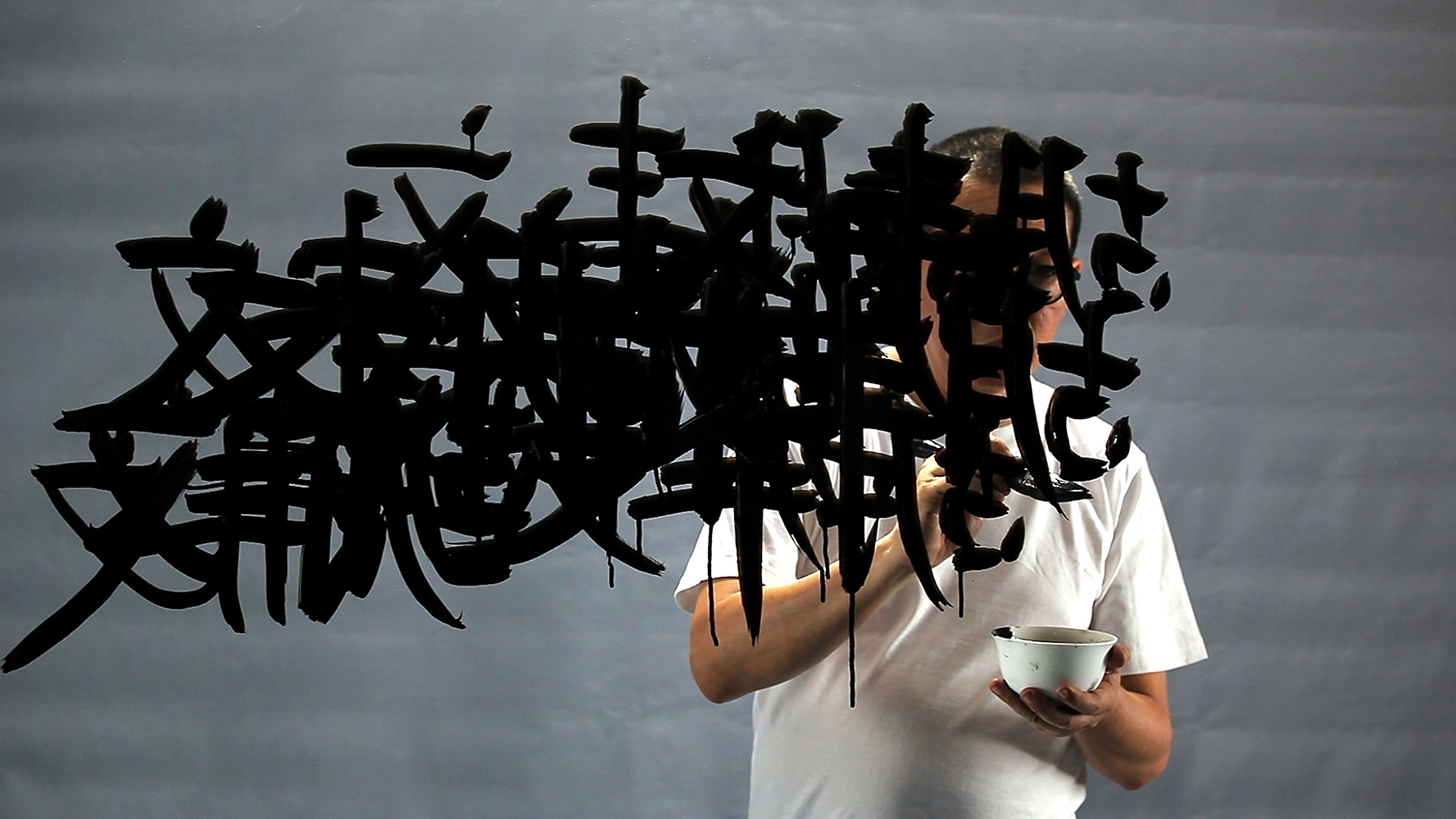 FX Harsono, 𝘞𝘳𝘪𝘵𝘪𝘯𝘨 𝘪𝘯 𝘵𝘩𝘦 𝘙𝘢𝘪𝘯, video still, 2011, courtesy the artist and Museum of Contemporary Photography